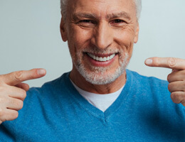 older man pointing to whiter teeth